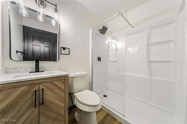 bathroom featuring hardwood / wood-style floors, vanity, toilet, and an enclosed shower