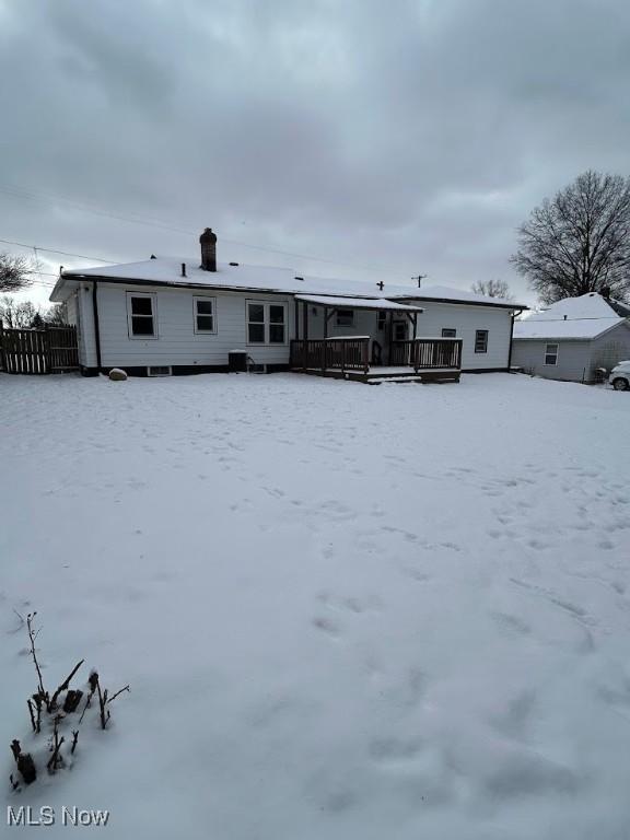 snow covered property with a deck