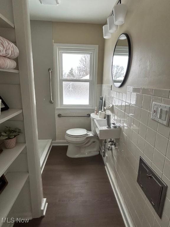 bathroom with hardwood / wood-style floors, tile walls, and a healthy amount of sunlight