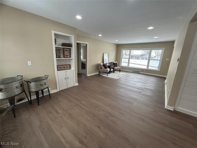 interior space featuring built in shelves and dark hardwood / wood-style floors