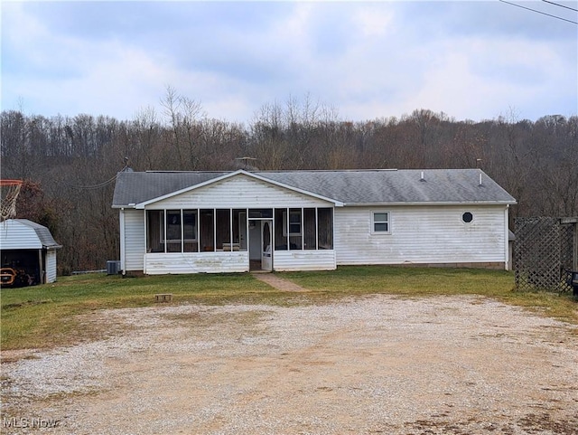 view of front of home featuring central AC, a sunroom, and a front yard