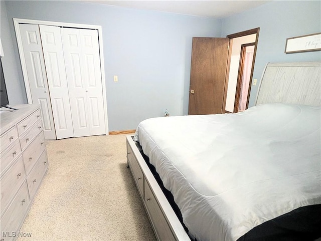 bedroom featuring light colored carpet and a closet