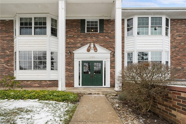 snow covered property entrance featuring french doors