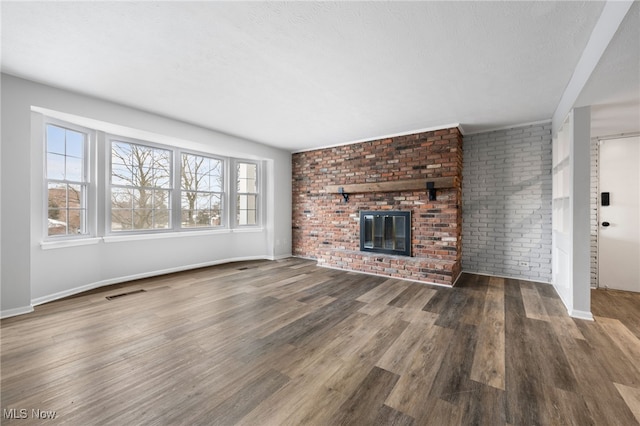 unfurnished living room with a fireplace, wood-type flooring, and a textured ceiling