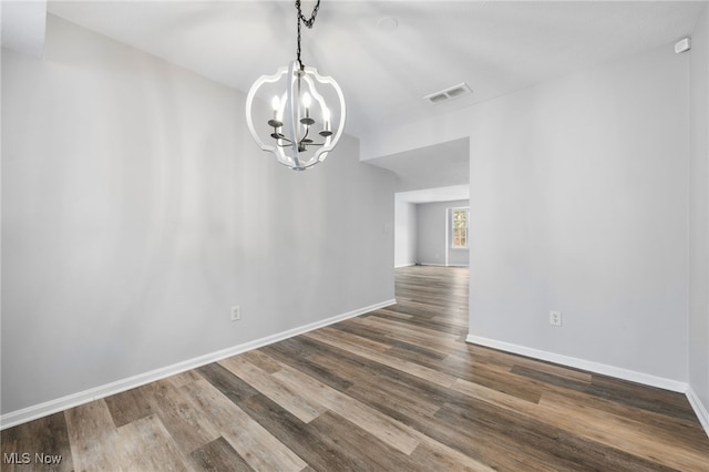 unfurnished dining area featuring hardwood / wood-style flooring and a chandelier