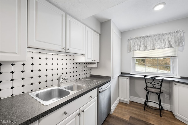 kitchen featuring backsplash, white cabinets, sink, stainless steel dishwasher, and dark hardwood / wood-style flooring