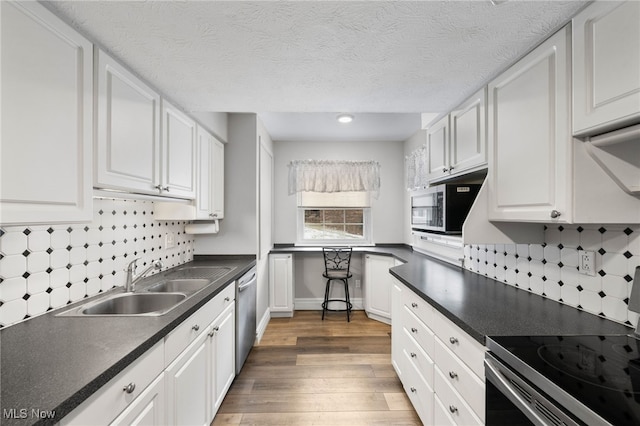 kitchen featuring white cabinets, sink, dark hardwood / wood-style floors, a textured ceiling, and appliances with stainless steel finishes