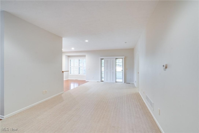 unfurnished room featuring light colored carpet