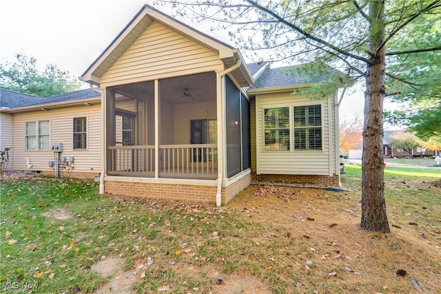 back of property featuring a sunroom and a yard