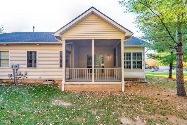 rear view of property with a yard and a sunroom