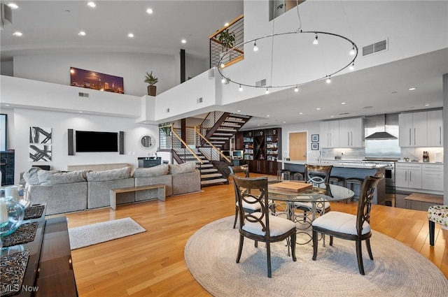 dining space featuring light hardwood / wood-style floors and a towering ceiling