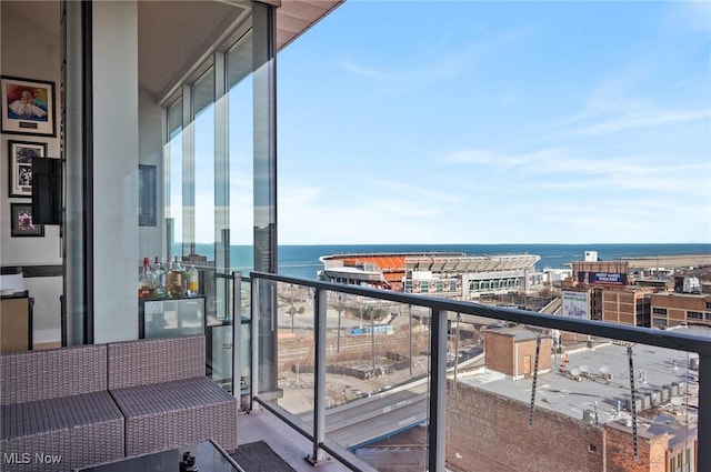 balcony featuring outdoor lounge area and a water view