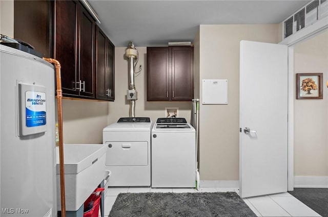 washroom with cabinets, sink, water heater, light tile patterned floors, and independent washer and dryer