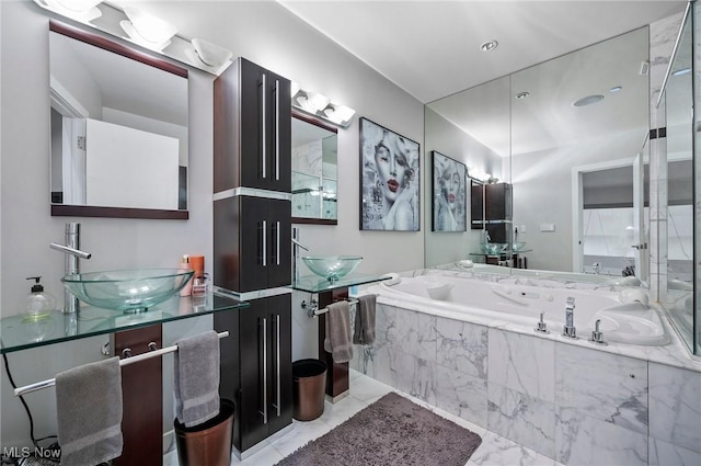 bathroom with tiled bath and vanity