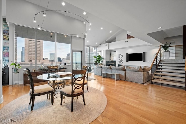 dining room featuring light hardwood / wood-style floors and high vaulted ceiling