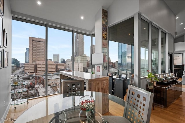 dining area with hardwood / wood-style floors, expansive windows, and plenty of natural light