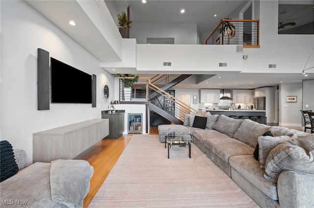 living room featuring light hardwood / wood-style flooring and a towering ceiling