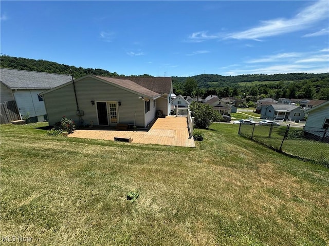 back of property featuring a lawn and a deck