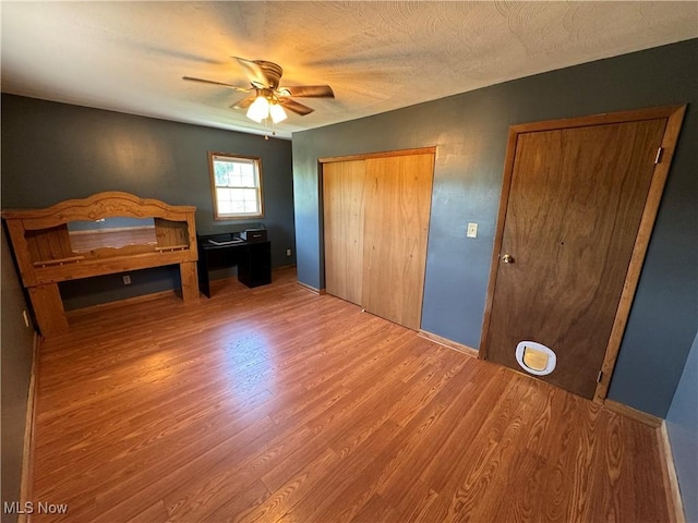 bedroom with ceiling fan, a textured ceiling, and hardwood / wood-style flooring