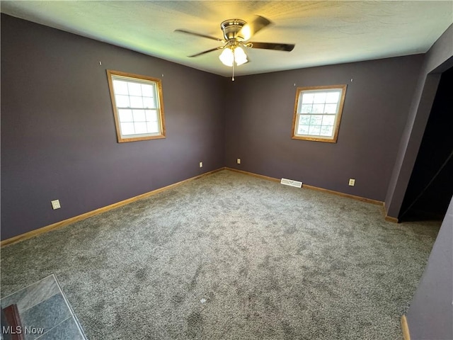 carpeted spare room featuring ceiling fan