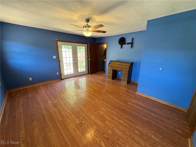 unfurnished living room with ceiling fan, french doors, and hardwood / wood-style flooring