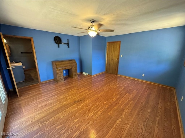 unfurnished living room featuring hardwood / wood-style flooring and ceiling fan