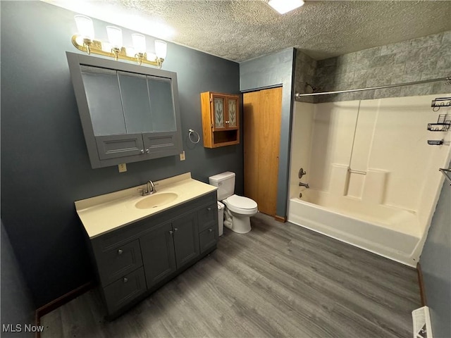 full bathroom featuring shower / bath combination, a textured ceiling, vanity, hardwood / wood-style flooring, and toilet