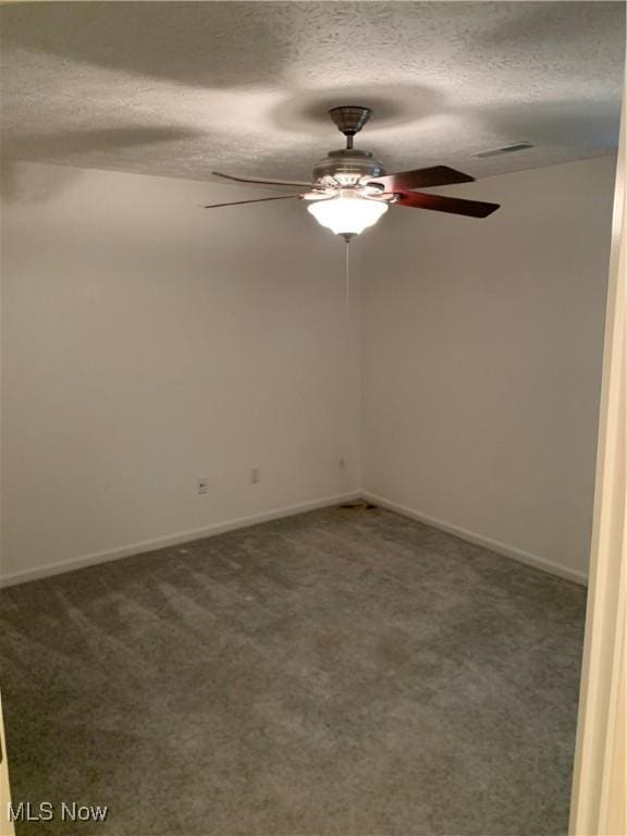 spare room featuring carpet and a textured ceiling