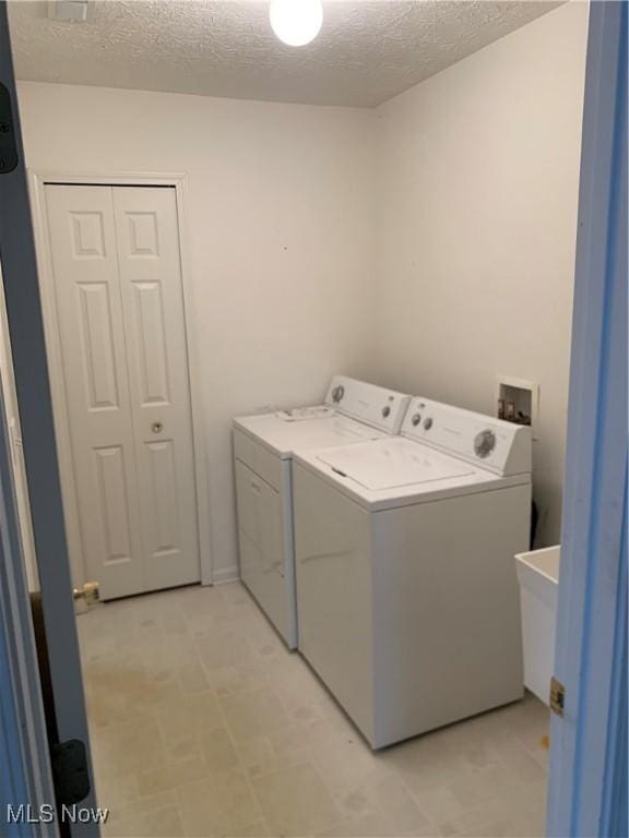 laundry room featuring independent washer and dryer and a textured ceiling