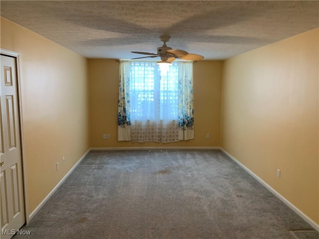 empty room featuring ceiling fan, carpet floors, and a textured ceiling