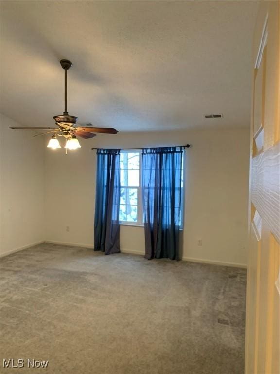 carpeted spare room featuring ceiling fan