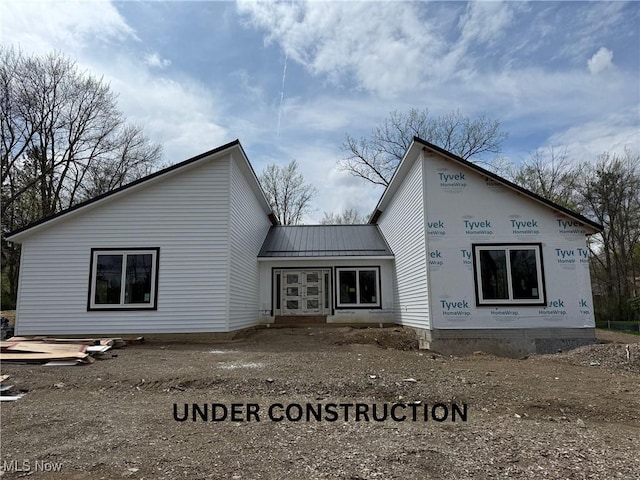 back of property with metal roof and a standing seam roof