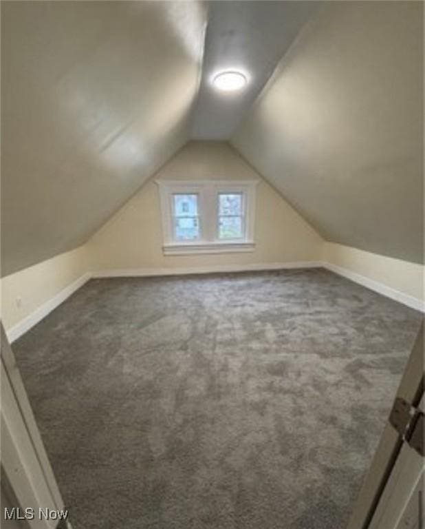 bonus room featuring dark carpet and lofted ceiling