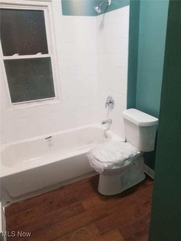 bathroom with hardwood / wood-style floors, toilet, and shower / bathtub combination