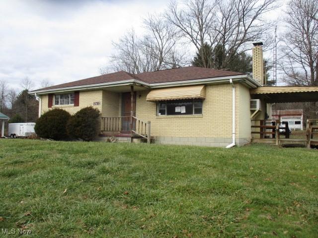 ranch-style home featuring a front yard and a carport