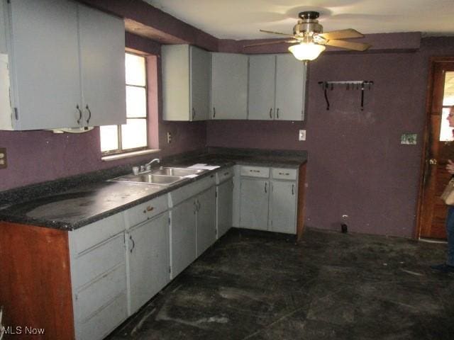 kitchen with ceiling fan, sink, and white cabinets