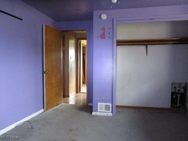 unfurnished bedroom featuring light colored carpet and a closet