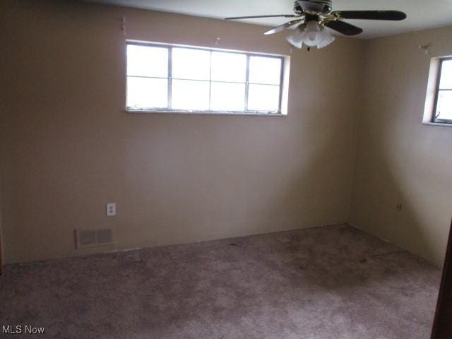 carpeted spare room with ceiling fan