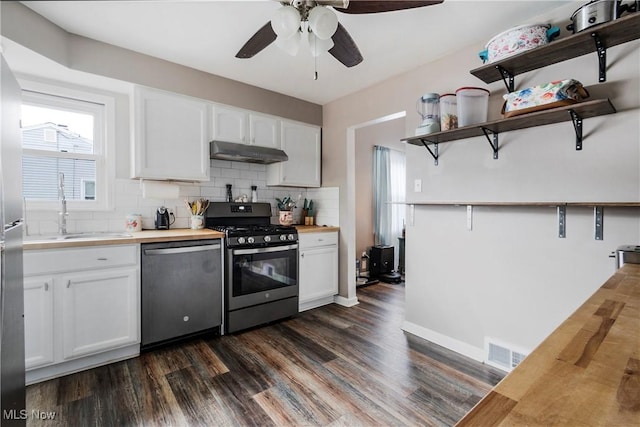 kitchen featuring decorative backsplash, stainless steel appliances, sink, white cabinets, and butcher block counters