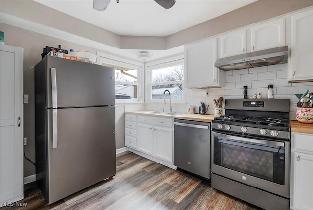 kitchen featuring stainless steel appliances, sink, dark hardwood / wood-style floors, white cabinetry, and butcher block counters