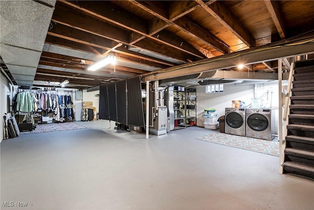 basement with heating unit and washer and clothes dryer