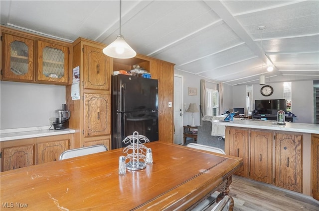 dining area with vaulted ceiling with beams and light wood-type flooring