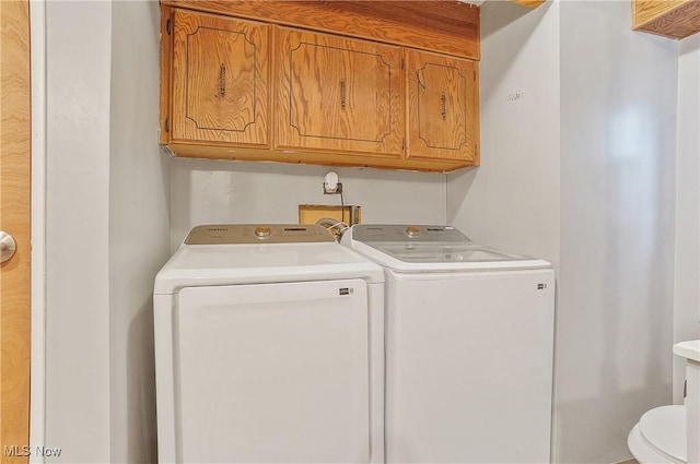 washroom featuring separate washer and dryer and cabinets