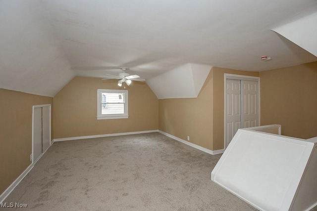 additional living space featuring ceiling fan, light carpet, and vaulted ceiling