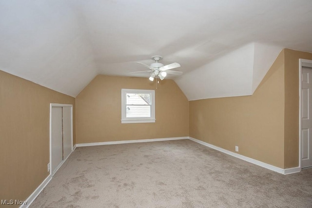 additional living space with light carpet, vaulted ceiling, and ceiling fan