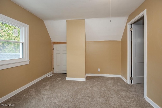 bonus room featuring light colored carpet and lofted ceiling