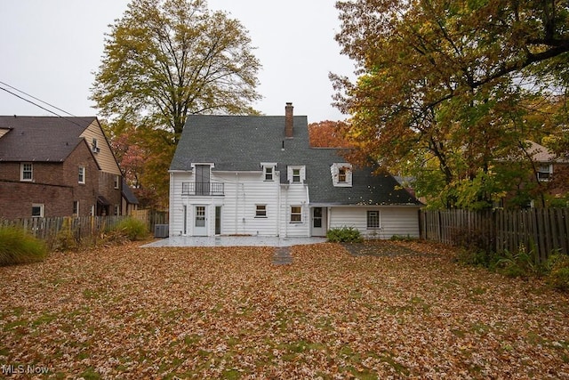 back of house featuring central AC, a balcony, and a patio