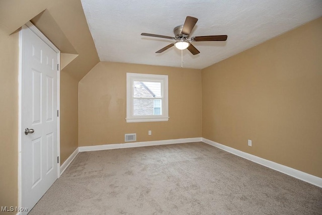 bonus room with ceiling fan, light carpet, and vaulted ceiling