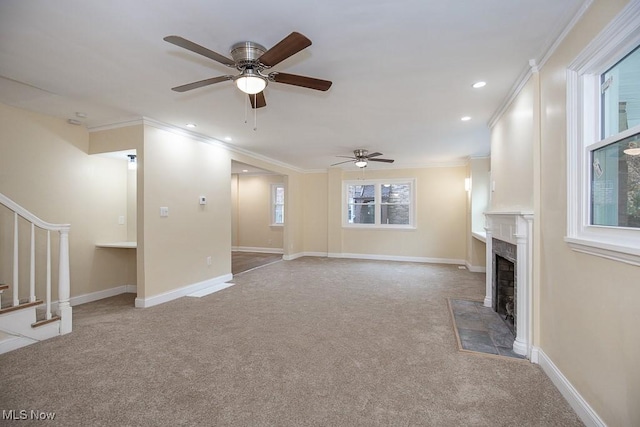 unfurnished living room with carpet, ceiling fan, crown molding, and a fireplace