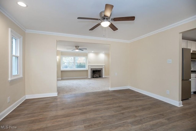 unfurnished living room featuring crown molding, a fireplace, ceiling fan, and dark hardwood / wood-style floors